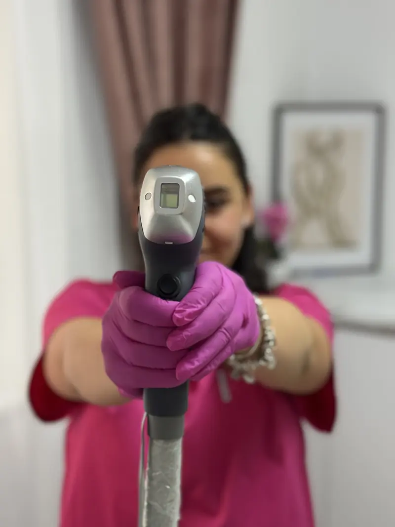 Terapeută certificată de la Alineea Beauty & Skin ținând manipulul laserului ERIDE Smart Dual pentru epilare definitivă